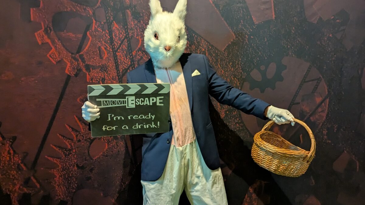 A photograph of the Easter Bunny holding a basket and a moviESCAPE sign.