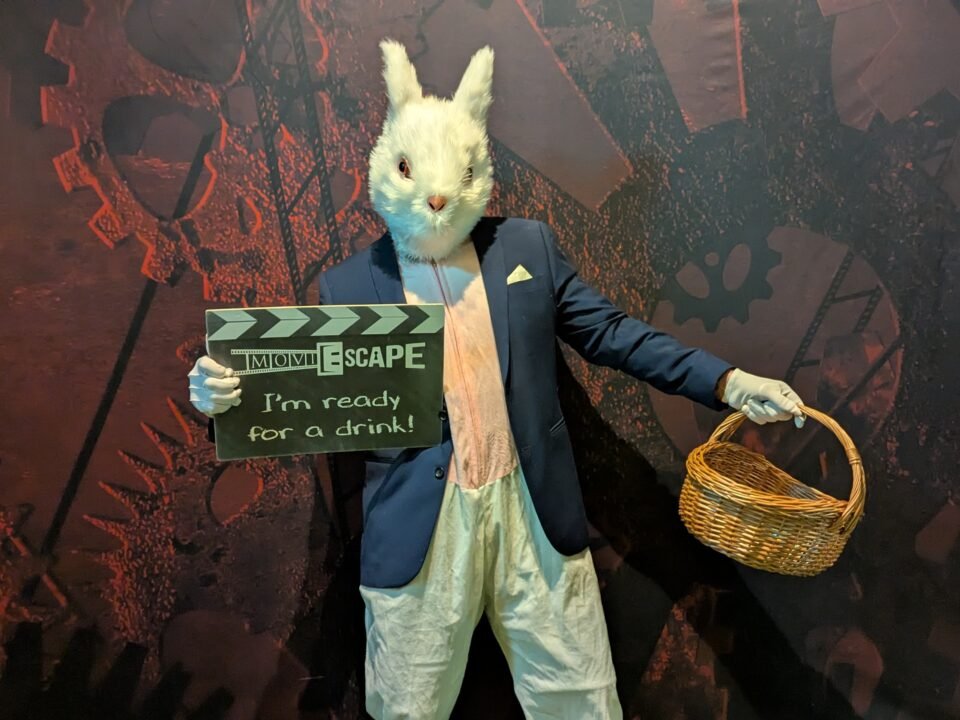 A photograph of the Easter Bunny holding a basket and a moviESCAPE sign.